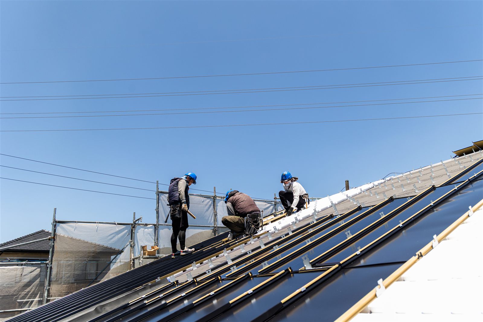 3人の職人が並んで Roof–1 を葺いていく屋根全景