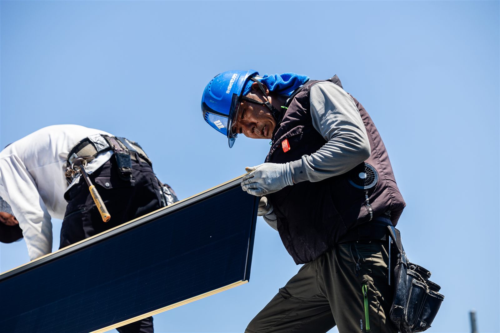 黒い Roof–1 モジュールを二人で運ぶ職人